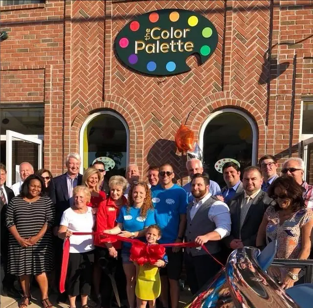 The Color Palette storefront on West Hoffman Avenue, with a crowd at the ribbon cutting